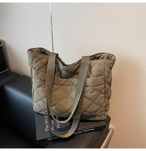 Close-up of military green quilted tote bag with diamond stitching and woven handle detail
