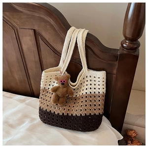 Detailed close-up of a three-tone woven crochet tote bag featuring a cute teddy bear charm
