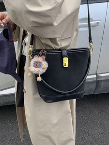 Borsa a secchiello in pelle nera con fibbia dorata e ciondolo di peluche, vista stile di vita