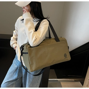 Close-up of olive green travel tote bag showing durable nylon texture and branded logo