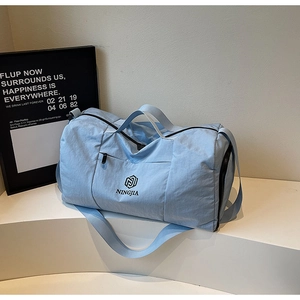 Light blue travel duffel bag with waterproof fabric and adjustable shoulder strap