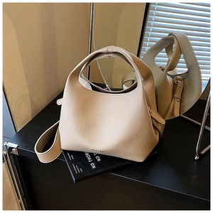 Macro detail of beige pebble leather handbag showing quality texture and BOCOMB logo