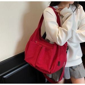 Red large capacity nylon crossbody bag with dual front pockets and adjustable strap
