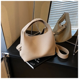 Detailed macro view of the beige pebble leather texture and handle of the bucket bag