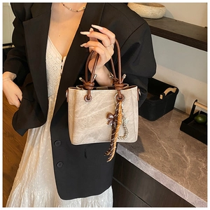 Detail of vintage bucket bag featuring resin ring handle and knot design for women