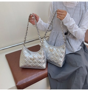 Detail view of two silver quilted handbags featuring chain straps and metal twist locks