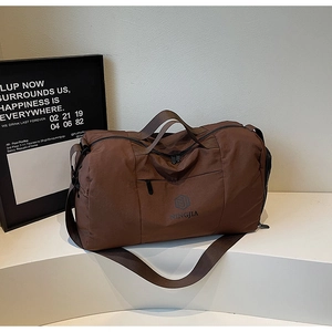 Detail of dark brown travel bag with dry-wet separation and adjustable shoulder strap