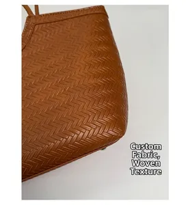 Détail de la texture tissée marron et du motif à chevrons sur le grand sac cabas