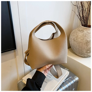 Detail of light brown lychee grain leather bucket bag with IROOMU embossed logo