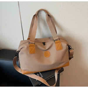 Detail view of the large capacity travel bag featuring reinforced leather corners and handles