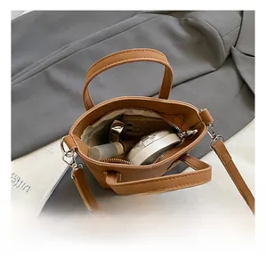 Vue de dessus montrant la capacité intérieure avec maquillage et téléphone dans le sac brun