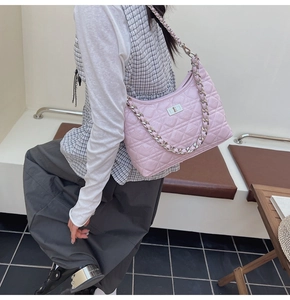 Close-up of pink quilted crossbody bag featuring a silver twist lock and chain strap