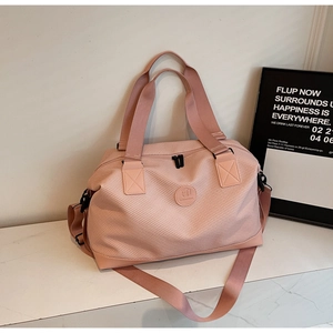 Detailed shot of pink quilted nylon travel bag with logo and adjustable strap