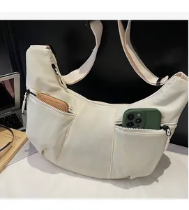 Close-up of a white dumpling crossbody bag showing spacious compartments for phone and wallet