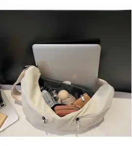 Internal view of ivory crossbody bag showing laptop, umbrella and spacious capacity