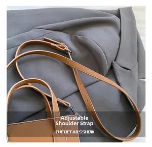 Détail de la bandoulière réglable en cuir marron avec boucle métallique sur un sac