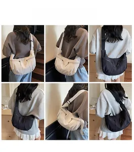 Detail view of crescent Hobo bag featuring dual front zippers and adjustable black strap
