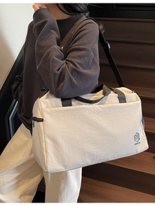 Minimalist cream travel bag with large capacity for gym and business trips with shoulder strap