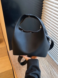 Minimalist black pebbled leather bucket bag with top handle for daily commute