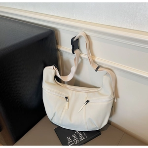 Détail du sac croissant en nylon blanc cassé avec deux zips frontaux et bandoulière