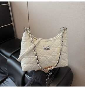 Close-up of white quilted leather bucket bag with silver chain and twist lock detail