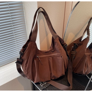 Detail of coffee brown nylon crossbody bag featuring front pockets and adjustable strap