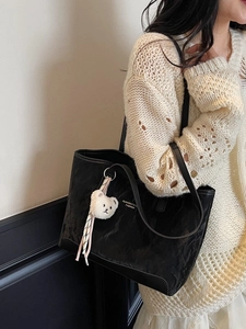Large black leather tote bag with soft texture and cute plush bear charm for daily use