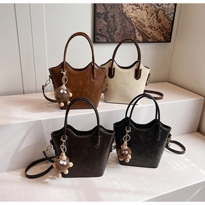 Retro faux leather bucket bags in four colors with shoulder straps and plush charms