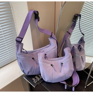 Détail de deux sacs demi-lune en nylon violet avec deux poches zippées sur le devant