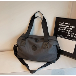 Detail of travel duffel bag with dark grey carbon fiber texture and adjustable strap