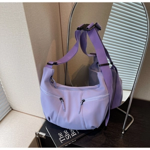 Vue détaillée du sac demi-lune en nylon lavande avec sangle et poches zippées