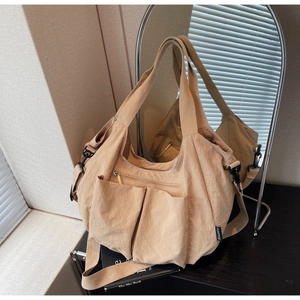 Detail of khaki tote bag showing multiple pockets, durable nylon fabric and mirror reflection