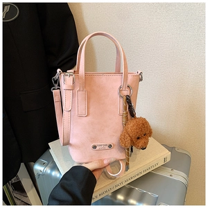Pink matte leather crossbody bag featuring a cute brown plush teddy bear charm
