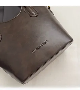 Close-up of dark brown faux leather texture with embossed Fashion & Bags lettering on tote