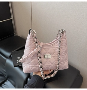 Detail of pink quilted hobo bag featuring glossy patent leather and silver chain strap