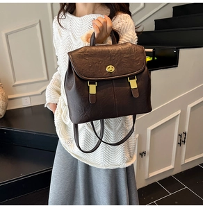 Detail of vintage dark brown PU leather backpack with round golden twist lock closure