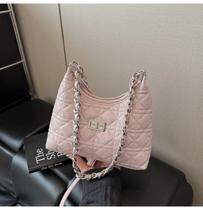 Detailed close-up of pink quilted crossbody bag with silver chain strap and metal lock