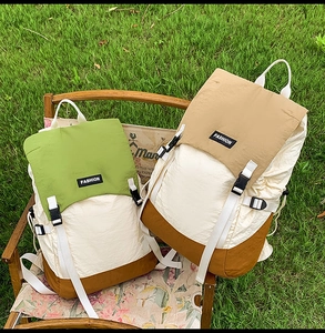 Outdoor backpacks in color-block green and khaki resting on a lawn chair
