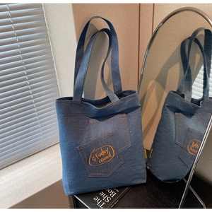 Detail of blue denim tote bag with Today Mood embroidery and double front pockets