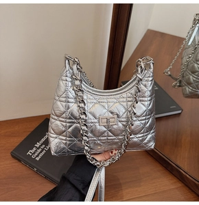 Detailed view of silver quilted leather texture and metallic chain strap on bucket bag