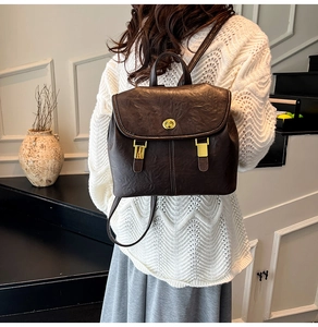 Detailed view of vintage dark brown backpack with golden twist lock and leather straps