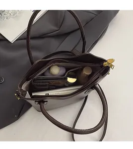 Top view of spacious interior of dark brown leather bucket bag with daily essentials