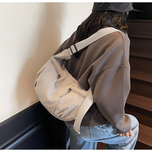 Détail du sac bandoulière en nylon avec sangle réglable et plusieurs poches zippées