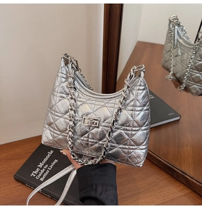 Detail of silver quilted bucket bag with metallic finish and elegant chain strap