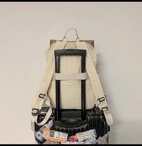 Detail of the back luggage strap on beige water-resistant backpack for easy travel