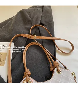 Dettaglio della borsa beige a quadretti con tracolla regolabile in pelle marrone