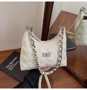 Detail of cream quilted bucket bag with silver chain strap and twist lock closure