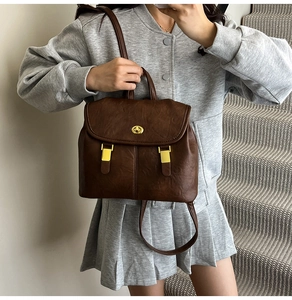 Close-up of brown vintage backpack with gold twist lock and fine leather texture details