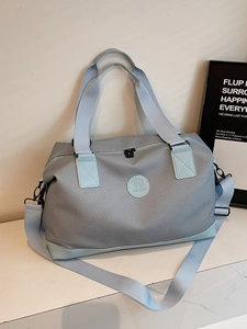 Light blue large travel duffel bag with durable woven texture and detachable strap