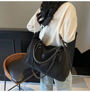 Detail of durable black nylon travel bag with leather handles and side zipper pocket